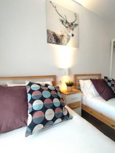 a bedroom with two beds and a table with a lamp at SKI & NATURE JAVALAMBRE in Camarena de la Sierra
