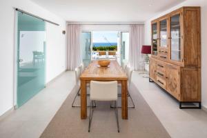 a dining room with a wooden table and white chairs at Casa Guincho in Carvoeiro