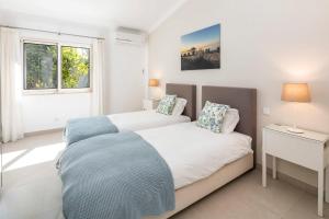 a bedroom with two beds and a window at Casa Guincho in Carvoeiro +15 photos