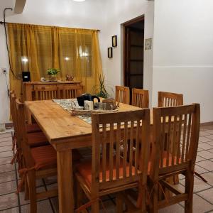 uma mesa de jantar com cadeiras e uma mesa de madeira em Casa en San Pedro para 8 totalmente equipada em San Pedro