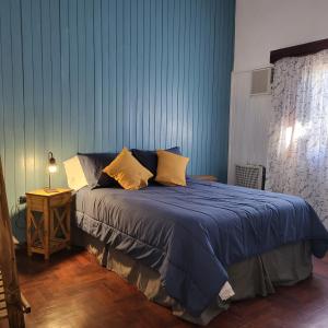 um quarto com uma cama azul e almofadas amarelas em Casa en San Pedro para 8 totalmente equipada em San Pedro