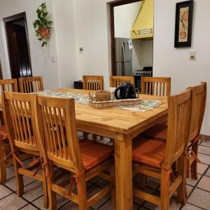 una mesa de madera con sillas y un hervidor de agua. en Casa en San Pedro para 8 totalmente equipada en San Pedro