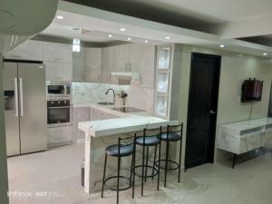 a large kitchen with a counter and stools in it at Lindo apartamento in Daule