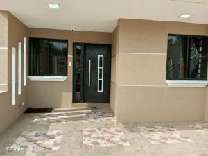 a house with a black door and two windows at Lindo apartamento in Daule