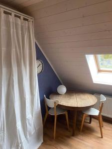 a table and chairs in a room with a window at Le petit 19 in Jodoigne