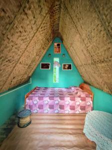 - une chambre mansardée avec un lit rose dans l'établissement MEPA HOMESTAY, à Cherrapunji