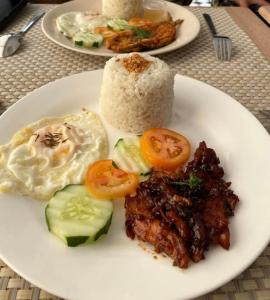 un plato de comida con carne, huevos y arroz en Nine Balconies Island Stay, en Boac