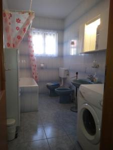 a bathroom with a toilet sink and a washing machine at Apartment Meri in Trogir