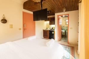 a bedroom with a large white bed and a kitchen at Marrakesh 1BDR w Jacuzzi Terrace Downtown Cairo in Cairo