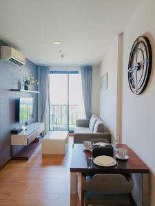 a living room with a table and a couch at The Astra Condo City Center Chiang Mai in Chiang Mai