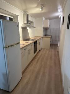 a kitchen with a white refrigerator and a wooden floor at Sebastiana's Monteur FeWo in Merzig +17 photos