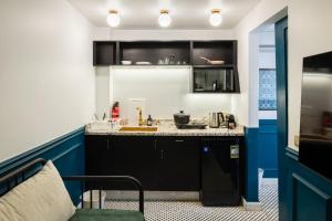 uma pequena cozinha com armários pretos e detalhes azuis em The Neat Nostalgic 2BDR Apt Cairo's Downtown no Cairo
