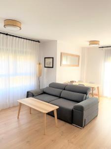 a living room with a couch and a table at Aixopluc - Apartamento centro rio Ritort in Camprodon