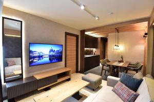 a living room with a large flat screen tv at Woodside Kopaonik Residences in Kopaonik