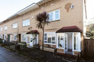 a brick house with a palm tree in front of it at Stepney Green beds to stay 24 in London