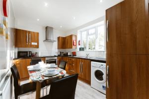 a kitchen with a table with chairs and a refrigerator at Stepney Green beds to stay 24 in London
