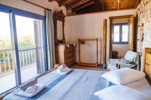 a bedroom with a bed and a large window at Chaihoutes stone villa into Olive farm in Zia in Ágios Dimítrios