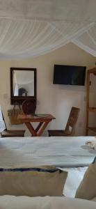 um quarto com uma cama, um espelho e uma televisão em Pousada Céu de Corumbau em Corumbau