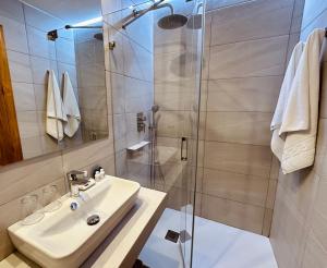 een badkamer met een wastafel en een douche bij LUZ Vejer Hospedería in Vejer de la Frontera