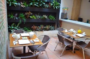 a restaurant with wooden tables and chairs and plants at Hotel Galeria la Trinidad in Cartagena de Indias