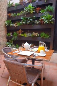 een houten tafel met stoelen en een tafel met planten bij Hotel Galeria la Trinidad in Cartagena