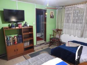 1 dormitorio con 1 cama y TV de pantalla plana en CASA LATINO, en Bogotá