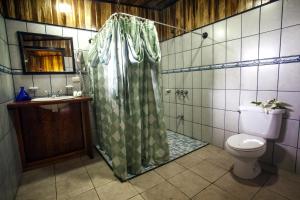 a bathroom with a shower curtain and a toilet at Mar Inn Costa Rica in Monteverde Costa Rica