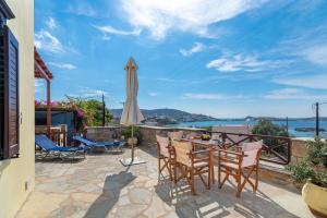 eine Terrasse mit einem Tisch und einem Sonnenschirm in der Unterkunft Reggina's Apartments in Finikas