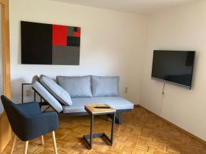 a living room with a couch and a tv at Zur Streuobstwiese 