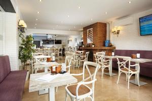 a restaurant with white tables and chairs and a counter at Hotel Villa Flamenca in Nerja