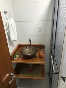 ein Badezimmer mit einem Spülbecken auf einer Holztheke in der Unterkunft Apartamento encantador em bairro Nobre. in Santa Cruz do Sul