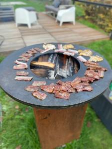 un cercle de jambon sur un grill sur une table dans l'établissement Villa veld en velo, à Brée
