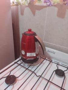 a red tea kettle sitting on top of a stove at La Positiva in Mar de Ajó