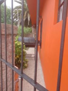 an orange building with a view through a fence at La Positiva in Mar de Ajó