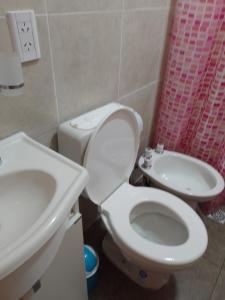 a bathroom with a white toilet and a sink at La Positiva in Mar de Ajó