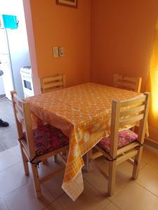 einen Esstisch und Stühle mit einem orangenen Tischtuch in der Unterkunft La Positiva in Mar de Ajó