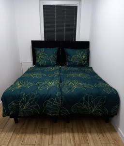 a bed with a blue comforter and two pillows at Apartament Różana Piątka in Kutno