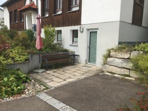 a patio with a bench and an umbrella in front of a building at Ferienwohnungen Fuchsteige in Heidenheim an der Brenz