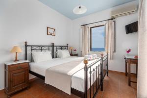 a bedroom with a large bed and a window at Reggina's Apartments in Finikas
