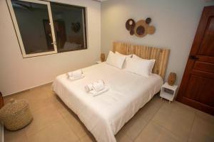 a bedroom with a large white bed with two towels on it at Beautiful 3 bed-roms Sea View Villa at INDIGO BAY in Koolbaai +29 photos