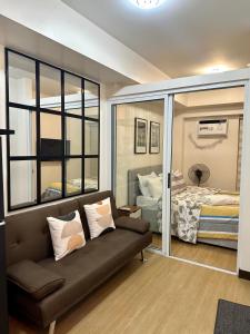 a living room with a couch and a bedroom at 1BR Condo Unit at Celandine Condominium Near Ayala Cloverleaf Mall in Manila