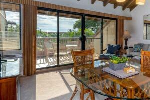 een woonkamer met een glazen tafel en stoelen bij Tropical Maui Kamaole B-Bldg in Wailea