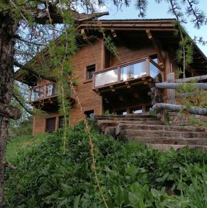 a log house with a balcony and stairs to it at Blackberry Apartment in Livigno