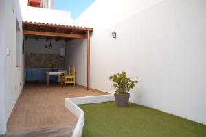 um pequeno pátio com um relvado verde numa parede branca em Loft La Cañada em La Orotava