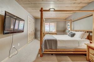 a bedroom with a bed and a flat screen tv at Pinehurst Retreat in Brian Head