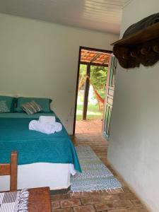 a bedroom with a bed and a sliding glass door at Pousada Cantinho do Mundo in Brumadinho