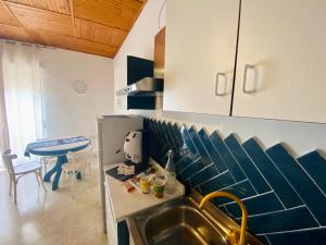 una cocina con armarios azules y blancos y fregadero en B&B Le Sorelle, en Giffoni Valle Piana