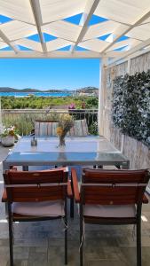einen Tisch und Stühle auf einer Terrasse mit Aussicht in der Unterkunft Apartmani Villa Lilliana in Tribunj