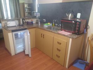 a small kitchen with a sink and a microwave at Departamento en Luis Guillon in Luis Guillón