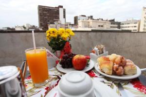a table with plates of food and a glass of orange juice at Mengo Palace Hotel in Rio de Janeiro